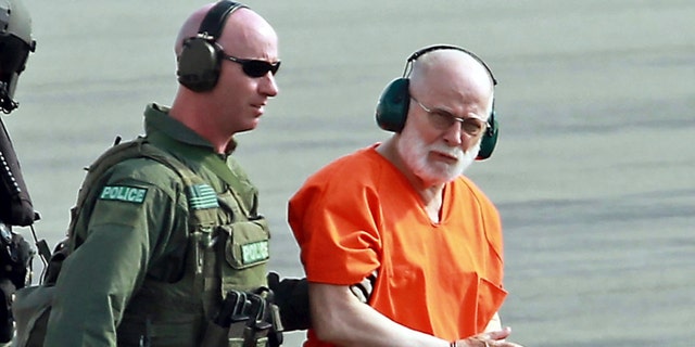 In this file photo from 2011, James "Whitey" Bulger, right, is escorted from a U.S. Coast Guard helicopter to a waiting vehicle at an airport in Plymouth, Massachusetts, after attending hearings in federal court in Boston. 