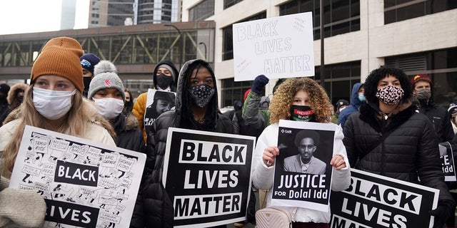 Black Lives Matter protesters, including Markeanna Tyus, center left, and Isis Atallah, center right, stand in the middle of 3rd Avenue South as they prepare to march from the Hennepin County Government Center to demand justice for Jacob Blake. (Anthony Souffle/Star Tribune via AP)