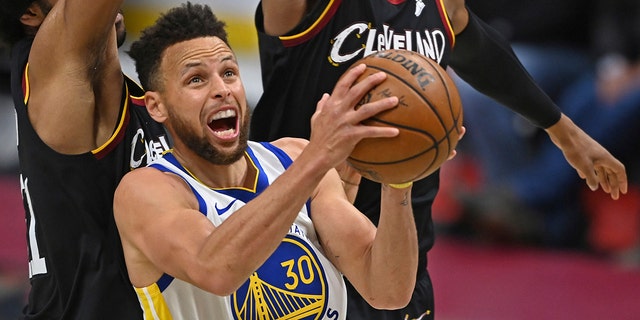 In this April 15, 2021, file photo, Golden State Warriors' Stephen Curry goes to the basket against Cleveland Cavaliers' Jarrett Allen (31) and Isaac Okoro during the second half of an NBA basketball game in Cleveland.