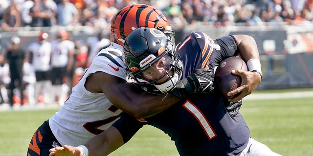 Chicago Bears quarterback Justin Fields (1) carries the ball and is tackled by Cincinnati Bengals cornerback Chidobe Awuzie during the second half of an NFL football game Sunday, Sept. 19, 2021, in Chicago.