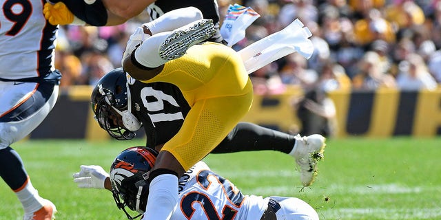 Pittsburgh Steelers wide receiver JuJu Smith-Schuster (19) is upended by Denver Broncos safety Kareem Jackson (22) during the first half of an NFL football game in Pittsburgh, Sunday, Oct. 10, 2021. Smith-Shuster was injured on the play and left the field.