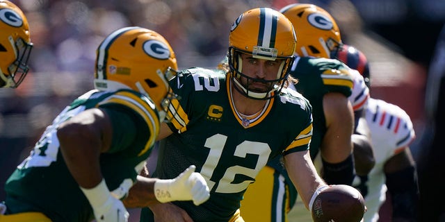 Green Bay Packers quarterback Aaron Rodgers (12) hands the ball off to running back A.J. Dillon during the first half of an NFL football game Sunday, Oct. 17, 2021, in Chicago.