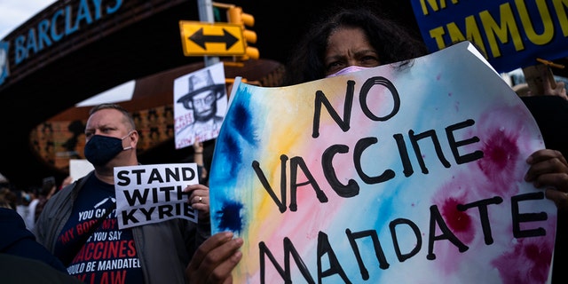 Protesters rallying against COVID-19 vaccination mandates gather in the street outside the Barclays Center before an NBA basketball game between the Brooklyn Nets and the Charlotte Hornets, Sunday, Oct. 24, 2021, in New York. (AP Photo/John Minchillo)
