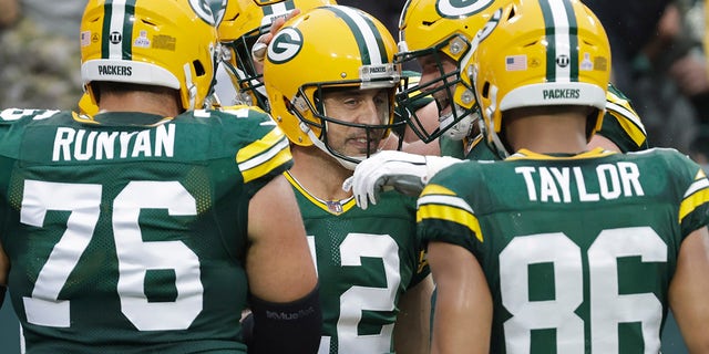 Green Bay Packers' Aaron Rodgers is congratulated after running for a touchdown during the first half of an NFL football game against the Pittsburgh Steelers Sunday, Oct. 3, 2021, in Green Bay, Wis.