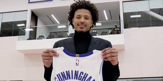 Detroit Pistons first-round pick Cade Cunningham holds up his game jersey after his press conference Friday, July 30, 2021, in Detroit.