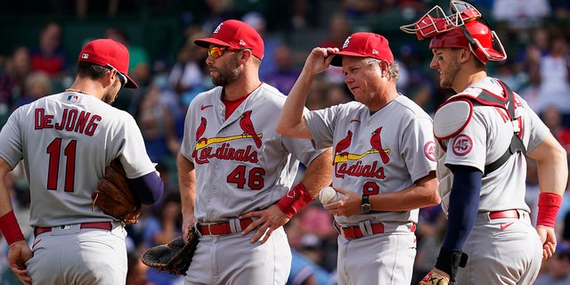 St. Louis Cardinals manager Mike Shildt, second from right, talks with shortstop Paul DeJong, left, first baseman Paul Goldschmidt, second from left, and catcher Andrew Knizner, right, as they wait for relief pitcher Andrew Miller during the sixth inning of a baseball game against the Chicago Cubs in Chicago, Sunday, Sept. 26, 2021. 