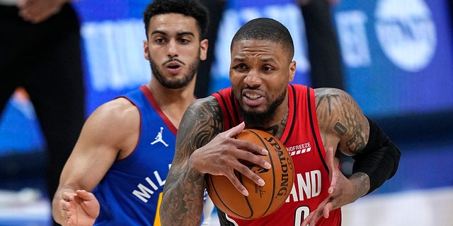 Portland Trail Blazers guard Damian Lillard (0) drives to the basket against Denver Nuggets guard Markus Howard during the second half of Game 5 of a first-round NBA basketball playoff series Tuesday, June 1, 2021, in Denver.