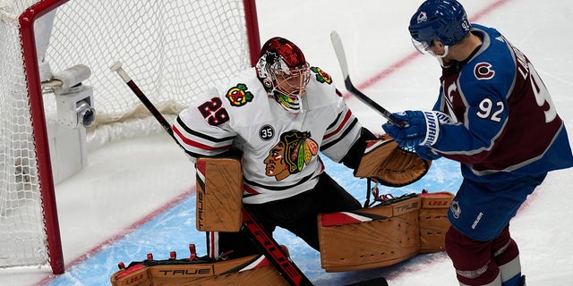 Chicago Blackhawks goaltender Marc-Andre Fleury, left, stops a shot off the stick of Colorado Avalanche left wing Gabriel Landeskog in the first period of an NHL hockey game Wednesday, Oct. 13, 2021, in Denver.