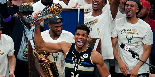 Milwaukee Bucks forward Giannis Antetokounmpo (34) with the championship trophy after defeating the Phoenix Suns in Game 6 of basketball's NBA Finals in Milwaukee, Tuesday, July 20, 2021. The Bucks won, 105-98.