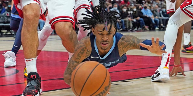 Memphis Grizzlies guard Ja Morant (12) dives for a loose ball against the Chicago Bulls Oct 15, 2021, during the first half at United Center in Chicago, Illinois.