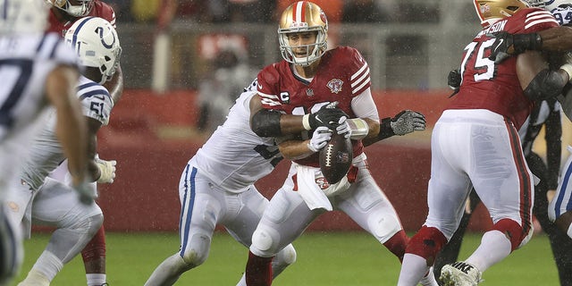 Jimmy Garoppolo fumbles in the third quarter while being tackled by Al-Quadin Muhammad of the Indianapolis Colts at Levi's Stadium on Oct. 24, 2021, in Santa Clara, California.