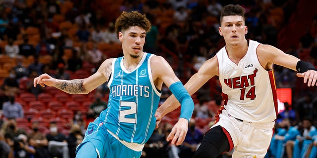 Charlotte Hornets guard LaMelo Ball drives the ball past Miami Heat guard Tyler Herro (14) during the first half Oct. 11, 2021, at FTX Arena in Miami, Florida.