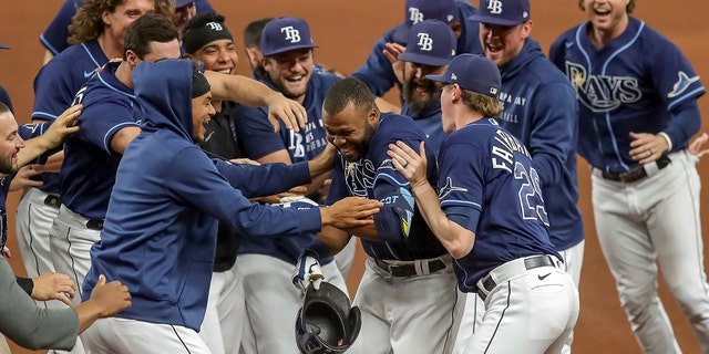 Tampa Bay Rays' Manuel Margot, center, is congratulated by teammates after his game-winning single against the Kansas City Royals during the 10th inning of a baseball game Wednesday, May 26, 2021, in St. Petersburg, Fla. The Rays won 2-1.