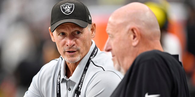 General manager Mike Mayock of the Las Vegas Raiders speaks to offensive line coach Tom Cable before a preseason game against the Seattle Seahawks at Allegiant Stadium on August 14, 2021 in Las Vegas, Nevada. The Raiders defeated the Seahawks 20-7.