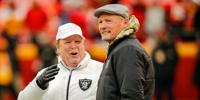 Oakland Raiders owner Mark Davis, left, watches his team during warmups with Oakland Raiders general manager Mike Mayock prior to the game against the Kansas City Chiefs at Arrowhead Stadium on December 1, 2019 in Kansas City, Missouri.