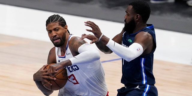 Los Angeles Clippers guard Paul George (13) fights to the basket against Dallas Mavericks' Tim Hardaway Jr, right, in the first half in Game 3 of an NBA basketball first-round playoff series in Dallas, Friday, May 28, 2021.