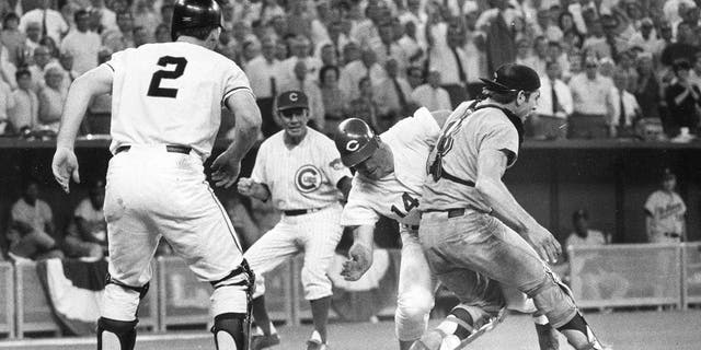 In this July 14, 1970, file photo, the National League's Pete Rose slams into American League catcher Ray Fosse to score the winning run during the 12th inning of the baseball All-Star Game in Cincinnati. Looking on are third base coach Leo Durocher and on-deck batter Dick Dietz (2).