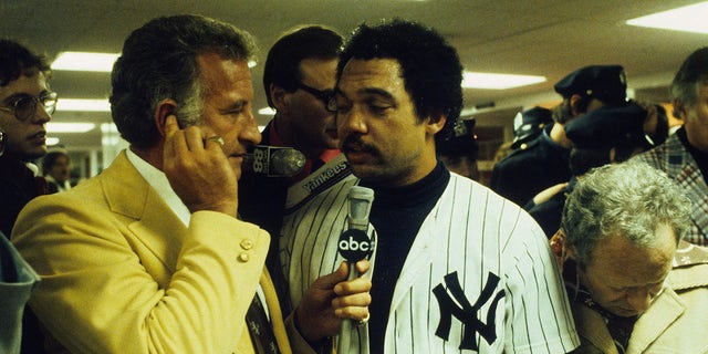 Reggie Jackson #44 of the New York Yankees is interviewed by Bob Uecker in the locker after the Yankees won the World Series against the Los Angeles Dodgers on Oct. 18, 1977 at Yankee Stadium in Bronx, New York.
