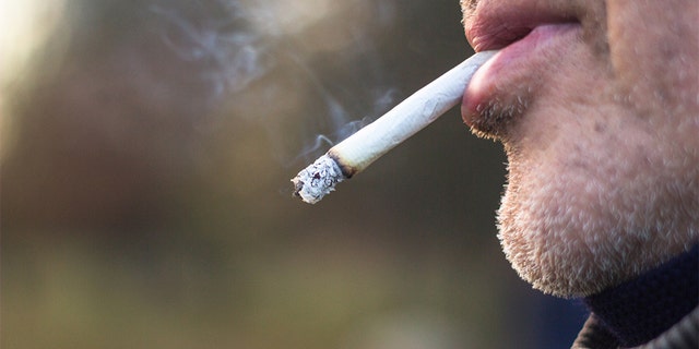 A man smokes a cigarette outdoors