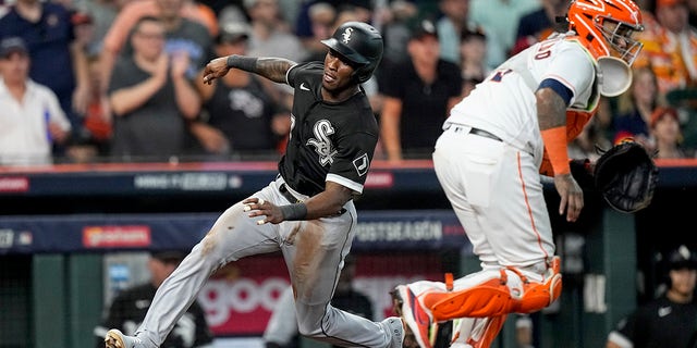 The Chicago White Sox' Tim Anderson, left, slides into home plate while scoring on an RBI single by Jose Abreu as Houston Astros catcher Martin Maldonado waits for a relay throw during the eighth inning in Game 1 of an American League Division Series Thursday, Oct. 7, 2021, in Houston.