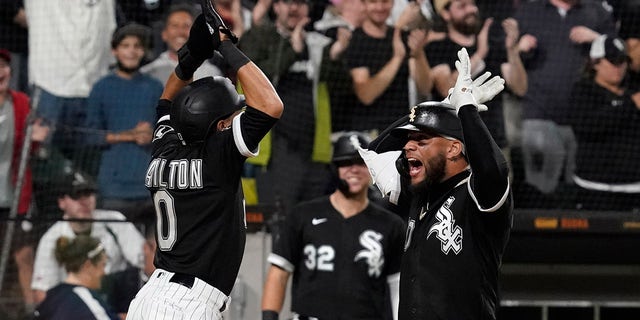 Chicago White Sox's Yoan Moncada, right, celebrates with Billy Hamilton after hitting a two-run home run during the eighth inning of a baseball game against the Detroit Tigers in Chicago, Saturday, Oct. 2, 2021.