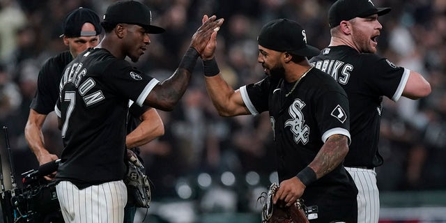 The Chicago White Sox's Tim Anderson (7) and Leury Garcia, center, celebrate with Liam Hendriks, right, after beating the Houston Astros 12-6 in Game 3 of the American League Division Series Sunday, Oct. 10, 2021, in Chicago.