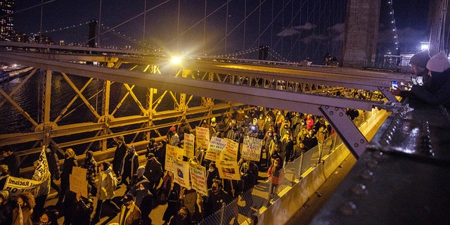 Demonstrators march across the Brooklyn Bridge Friday, Nov. 19, 2021, in New York, following the acquittal of Kyle Rittenhouse in Kenosha, Wis. (AP Photo/Jeenah Moon)