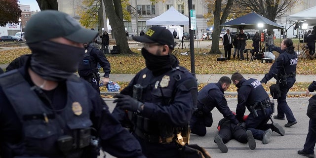 A protester is taken into custody by police outside the Kenosha County Courthouse, Wednesday, Nov. 17, 2021 in Kenosha, Wis., during the Kyle Rittenhouse murder trial. Rittenhouse is accused of killing two people and wounding a third during a protest over police brutality in Kenosha, last year. (AP Photo/Paul Sancya)