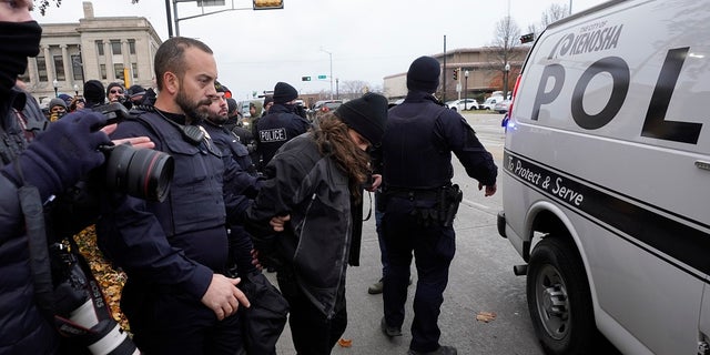 Kenosha police take a person into custody outside the Kenosha County Courthouse, Thursday, Nov. 18, 2021 in Kenosha, Wis., during the Kyle Rittenhouse murder trial. Rittenhouse is accused of killing two people and wounding a third during a protest over police brutality in Kenosha, last year. (AP Photo/Paul Sancya)