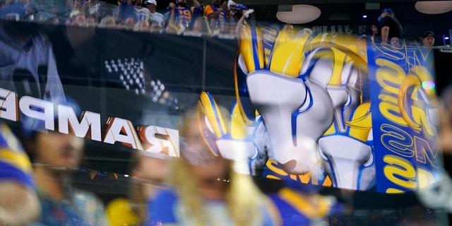 FILE - Fans are seen behind logos from the Los Angeles Rams at SoFi stadium during the first half of an NFL football game against the Chicago Bears, Sept. 12, 2021, in Inglewood, Calif. 