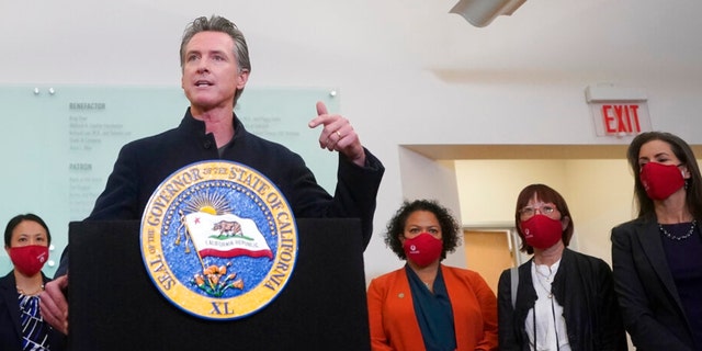 Gov. Gavin Newsom speaks at a news conference after receiving a Moderna COVID-19 vaccine booster shot at Asian Health Services in Oakland, Calif., Wednesday, Oct. 27, 2021. Also pictured are Assemblymember Mia Bonta, third from bottom right, Supervisor Wilma Chan and Oakland Mayor Libby Schaaf, right. (AP Photo/Jeff Chiu) 