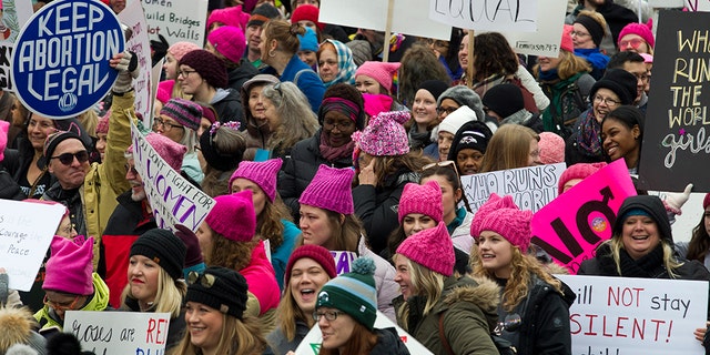 Demonstrators hold up their banners as they march on Pennsylvania Avenue during the Women's March in Washington on Saturday, Jan. 19, 2019. (AP Photo/Jose Luis Magana)