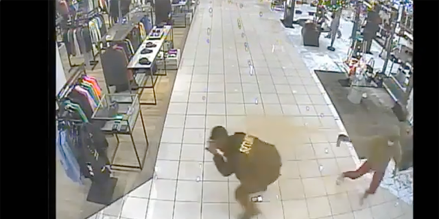 Photo of security guard getting hit with bear spray in a Nov. 24 robbery by a gang of thieves in Los Angeles.