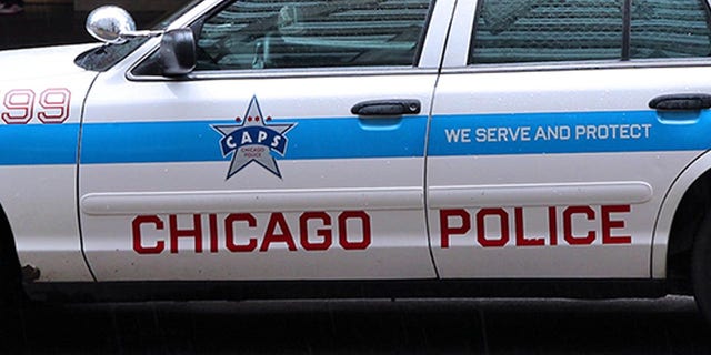 Chicago, United States - June 26, 2013: People walk past police car on June 26, 2013 in Chicago. Chicago Police Department is one of oldest police forces in the world, dating back to 1837.