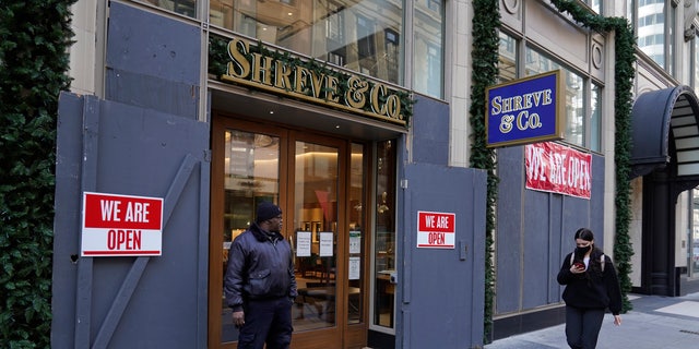 A security guard stands outside the heavily boarded Shreve &amp;amp; Co. jewelry store in San Francisco, Thursday, Dec. 2, 2021. (AP Photo/Eric Risberg)