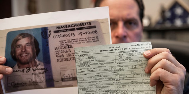 U.S. Marshal Peter J. Elliott holds the birth certificate and a copy of the driver's license of Ted Conrad on Dec. 16, 2021 at the Carl B. Stokes U.S. Courthouse in Cleveland. (AP Photo/Ken Blaze)