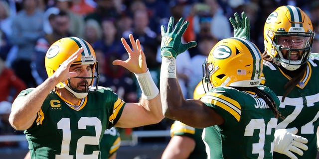 Oct 17, 2021; Chicago, IL, USA;  Green Bay Packers quarterback Aaron Rodgers (12) celebrates scoring a touchdown in the fourth quarter with running back Aaron Jones (33) during their football game Sunday, October 17, 2021, at Soldier Field in Chicago, Ill. Green Bay won 24-14. 