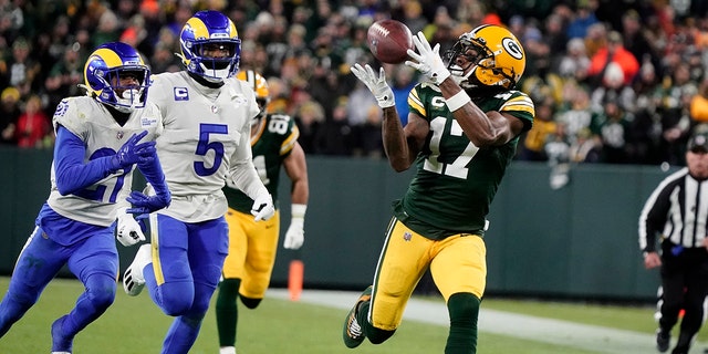 Green Bay Packers' Davante Adams catches a long pass in front of Los Angeles Rams' Jalen Ramsey during the first half of an NFL football game Sunday, Nov. 28, 2021, in Green Bay, Wisconsin.