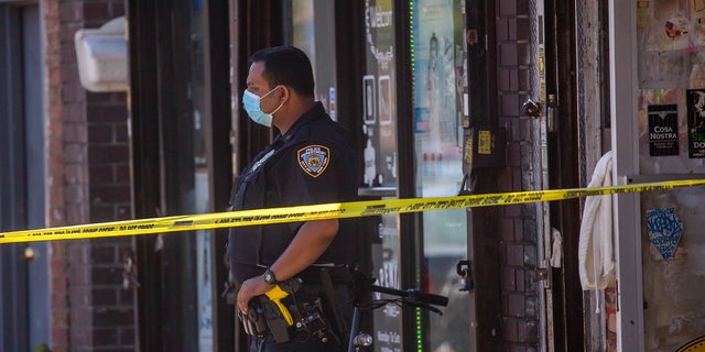 An NYPD officer monitors a crime scene in New York City. 