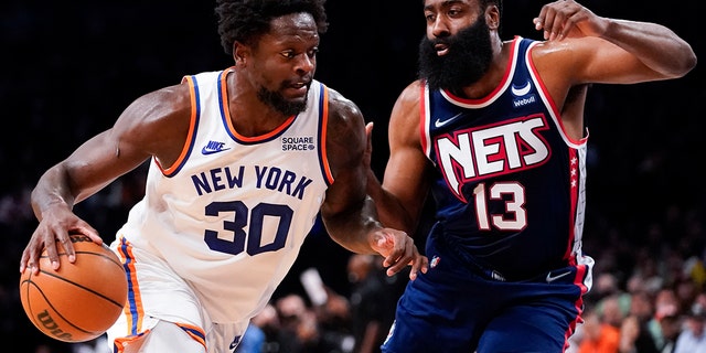 New York Knicks forward Julius Randle (30) drives against Brooklyn Nets guard James Harden (13) during Tuesday, Nov. 30, 2021, in New York. 