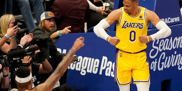 Los Angeles Lakers' Russell Westbrook (0) celebrates after sinking a basket as fans look on in the second half of an NBA basketball game in Dallas, Wednesday, Dec. 15, 2021.