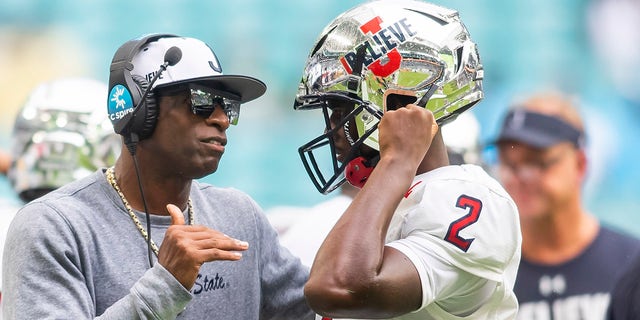 Jackson State Tigers head coach Deion Sanders speaks with Jackson State Tigers quarterback and son Shedeur Sanders (2) during the Orange Blossom Classic game between the Florida A and M Rattlers and the Jackson State Tigers Sept. 5, 2021, at Hard Rock Stadium in Miami Gardens, Fla. 