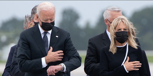 TOPSHOT - US President Joe Biden looks down alongside First Lady Jill Biden as they attend the dignified transfer of the remains of a fallen service member at Dover Air Force Base in Dover, Delaware, August, 29, 2021, one of the 13 members of the US military killed in Afghanistan last week. (Photo by SAUL LOEB / AFP) (Photo by SAUL LOEB/AFP via Getty Images)