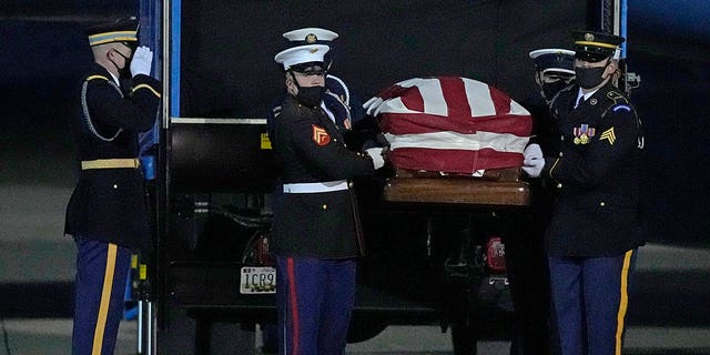 A joint services military bearer team moves the casket of former Sen. Bob Dole, R-Kan., after arriving at the airport in Salina, Kan., Friday, Dec. 10, 2021. 