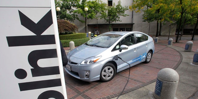 A Toyota Prius Hybrid charges during the unveiling of the Blink electric vehicle charging station that will charge up vehicles in Portland and other key metropolitan areas in Portland, Ore.  (AP Photo/Rick Bowmer)