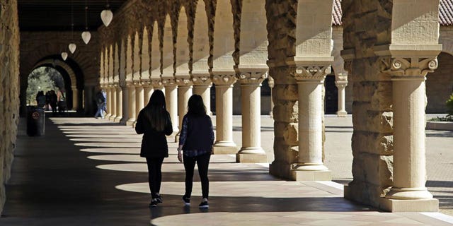 Students walk on the Stanford University campus in Stanford, California, on March 14, 2019.