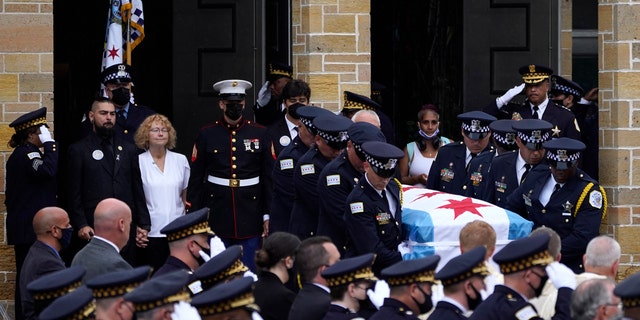 Elizabeth French, in white, and her son Andrew, left, follow the casket of her daughter, Chicago police officer Ella French, after a funeral service at the St. Rita of Cascia Shrine Chapel Thursday, Aug. 19, 2021, in Chicago. (AP Photo/Charles Rex Arbogast, File)