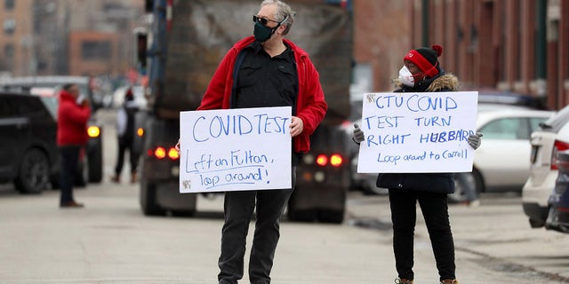 Chicago Teachers Union workers direct cars lined up for COVID-19 testing outside of CTU headquarters on Thursday, Dec. 30, 2021.