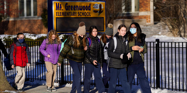 Students at the Mt. Greenwood Elementary School in Chicago depart after a full day of classes Monday, Jan. 10, 2022. (AP Photo/Charles Rex Arbogast) 