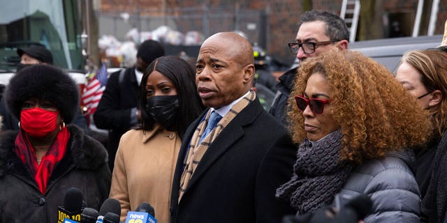 New York City Mayor Eric Adams, middle, speaks during a news conference outside an apartment building where a deadly fire occurred in the Bronx on Sunday, Jan. 9, 2022, in New York. (AP Photo/Yuki Iwamura)
